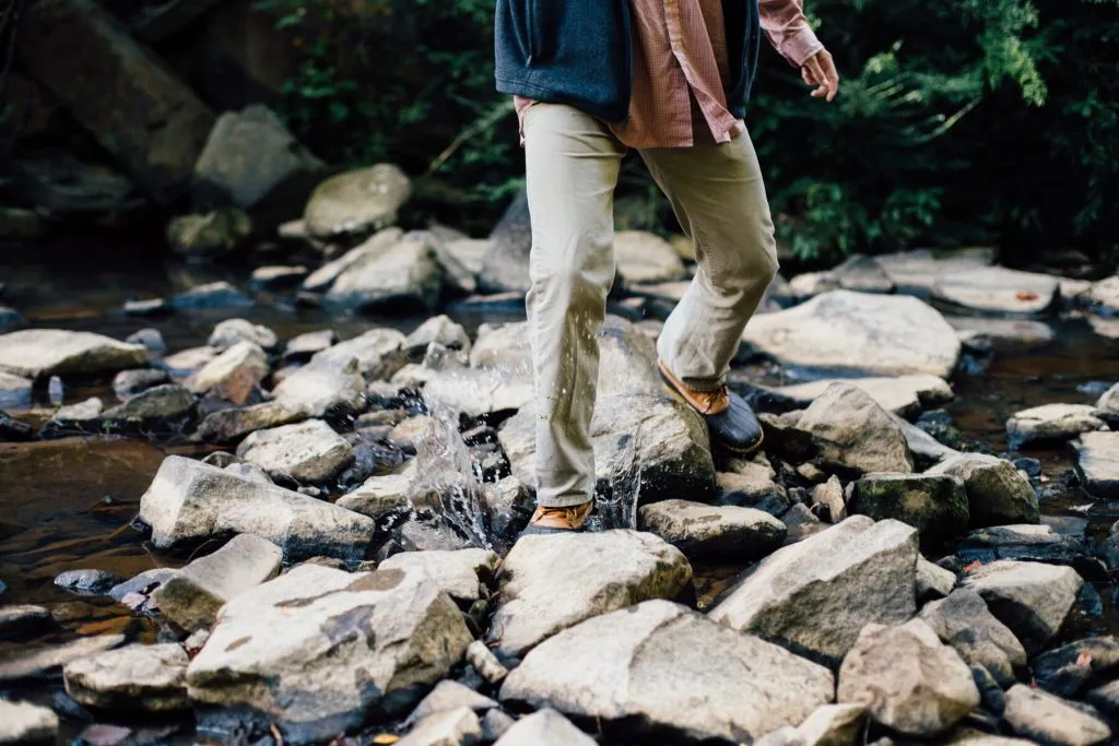Man hiking through rocky stream